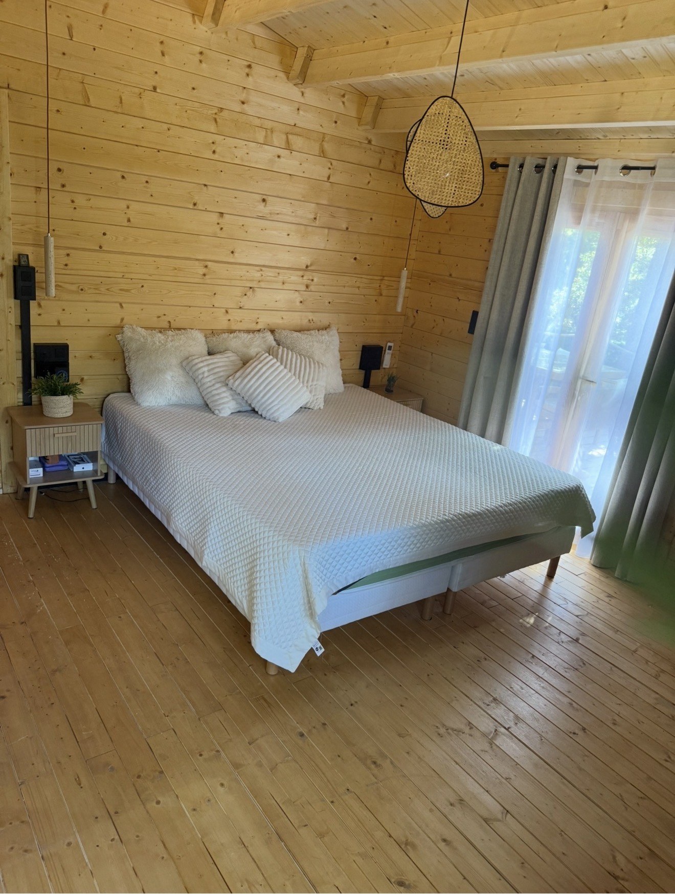 Chambre avec lit double dans un chalet en bois du Domaine des Parcs