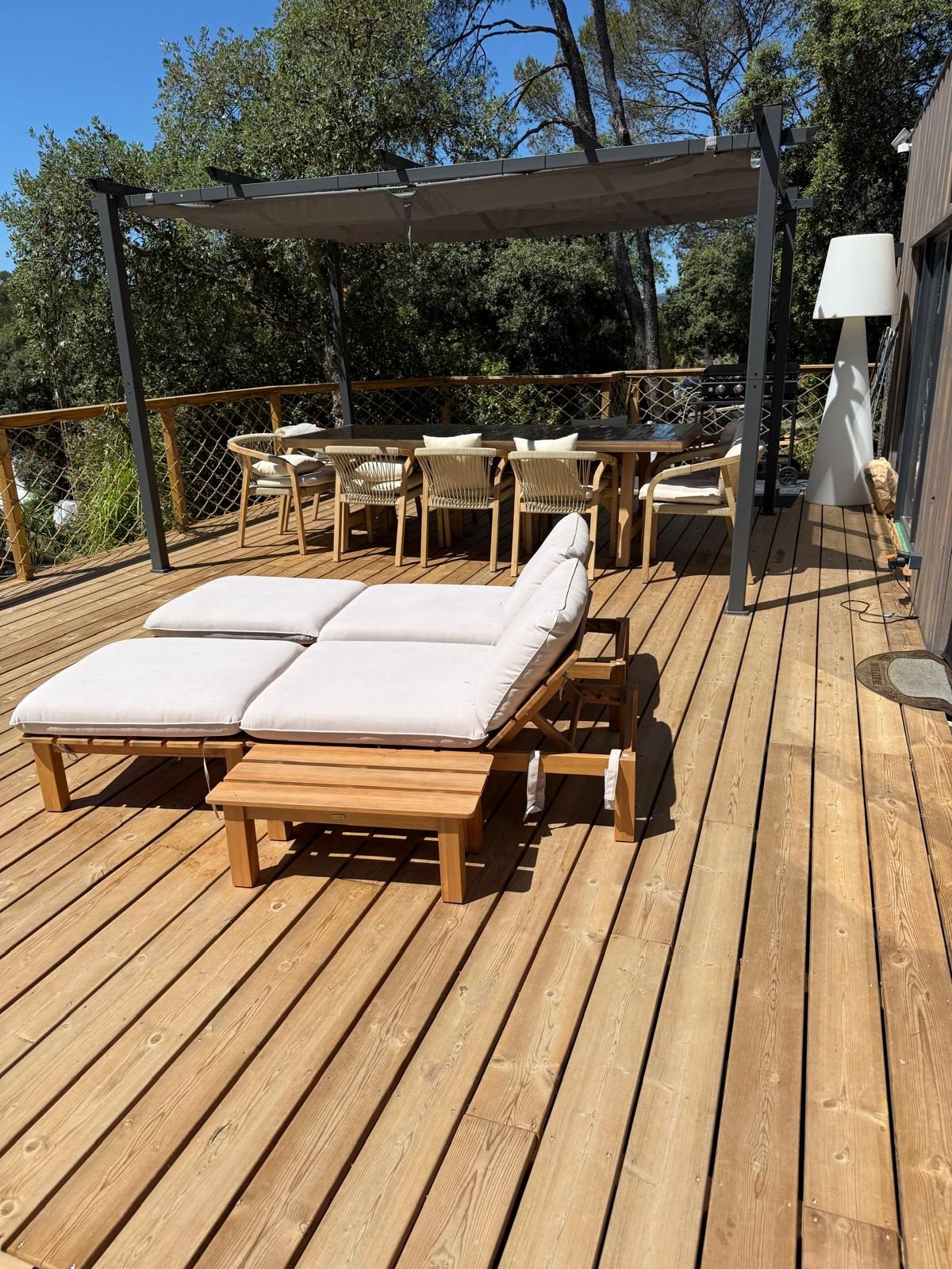 Espace repas extérieur sous pergola sur la terrasse d'un chalet