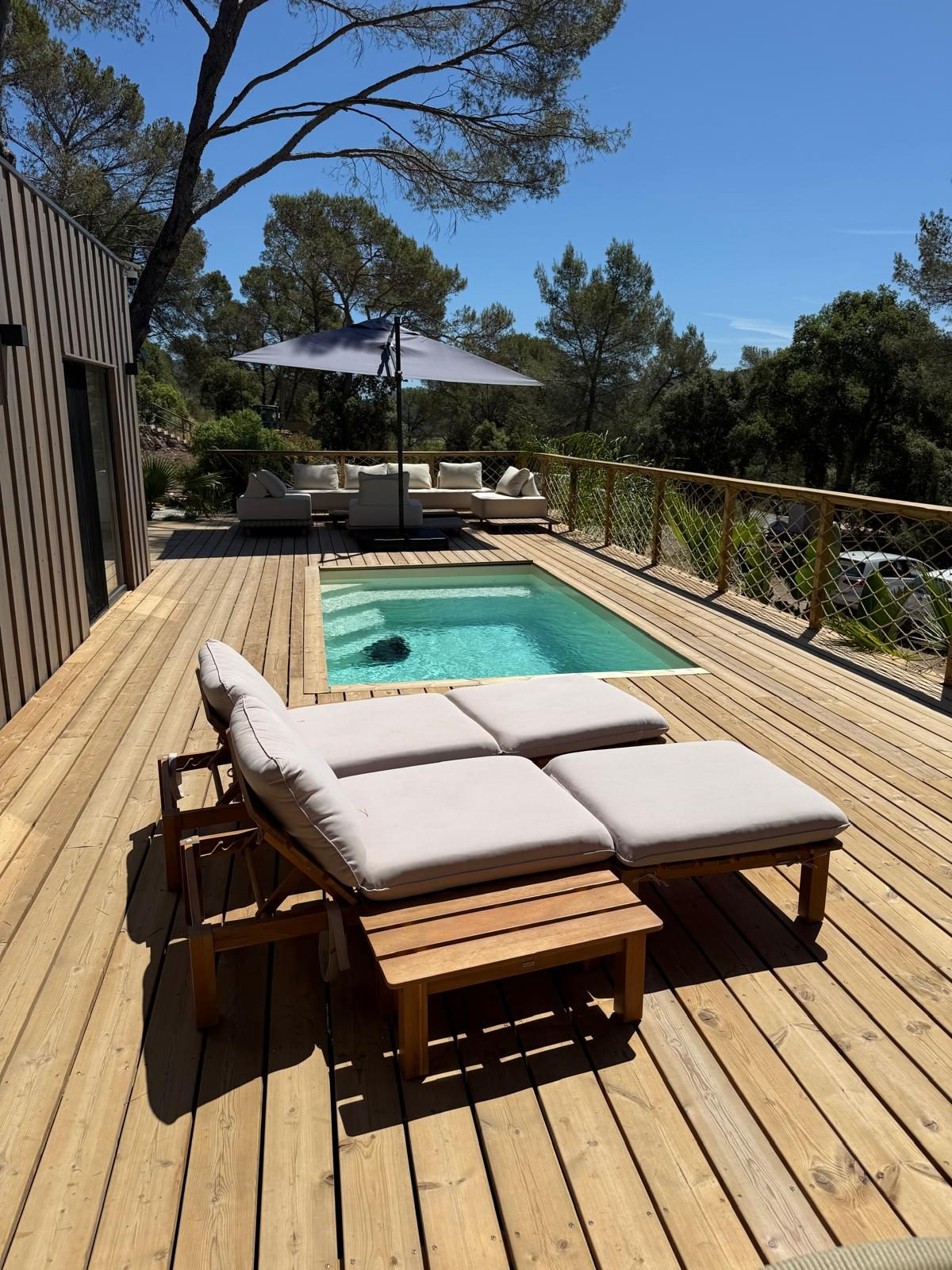 Piscine et transats sous les pins d'un chalet