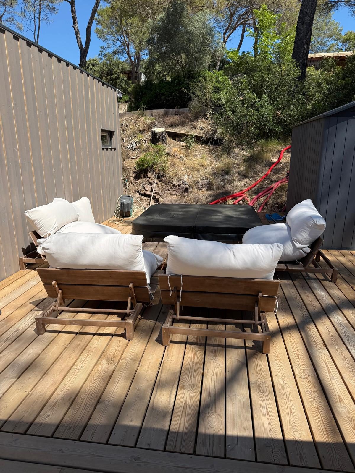 Terrasse aménagée avec fauteuils dans un écrin de verdure