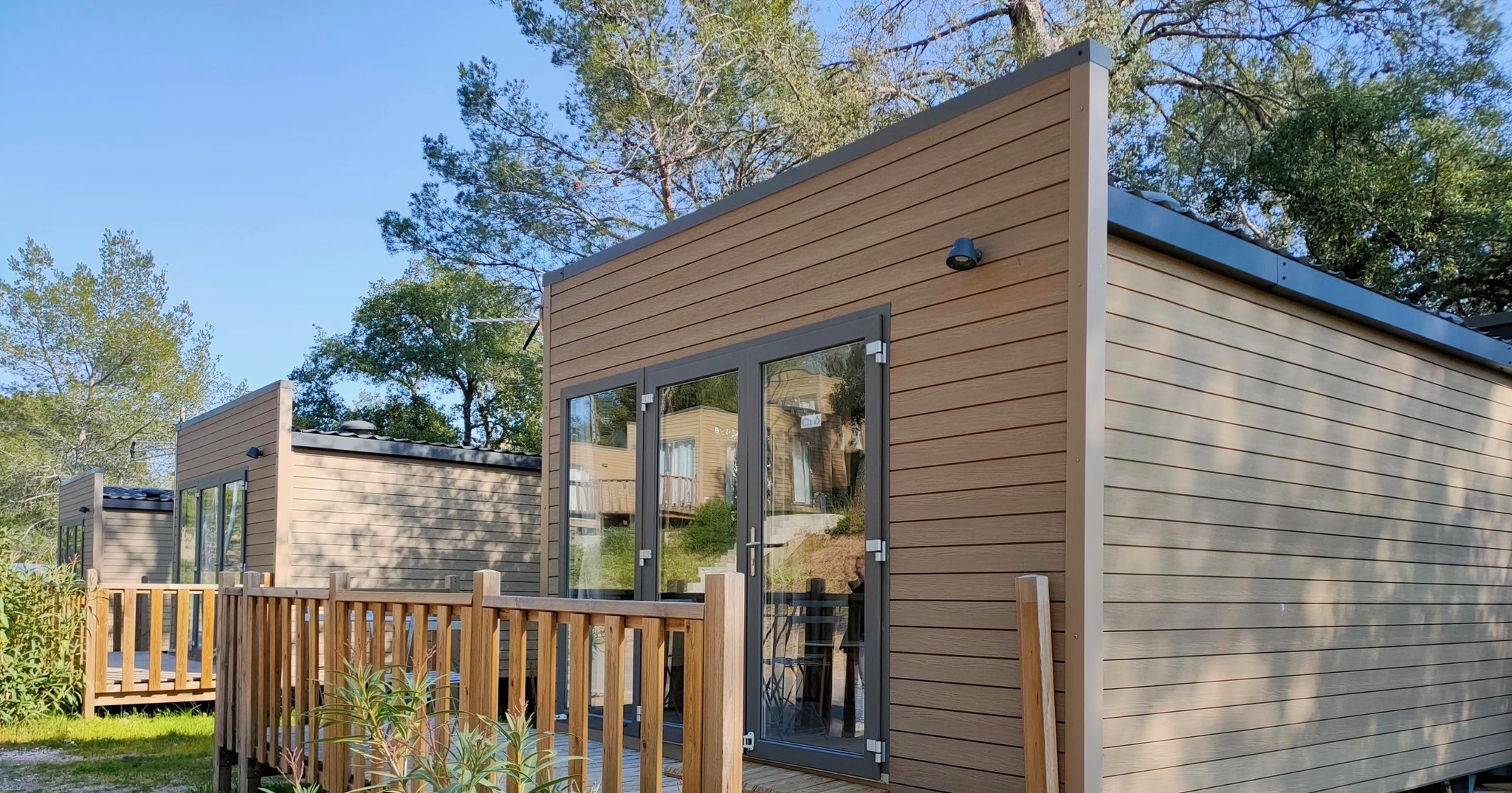 Chalet au bardage bois du domaine, sa terrasse et sa pinède, sous le ciel du Var