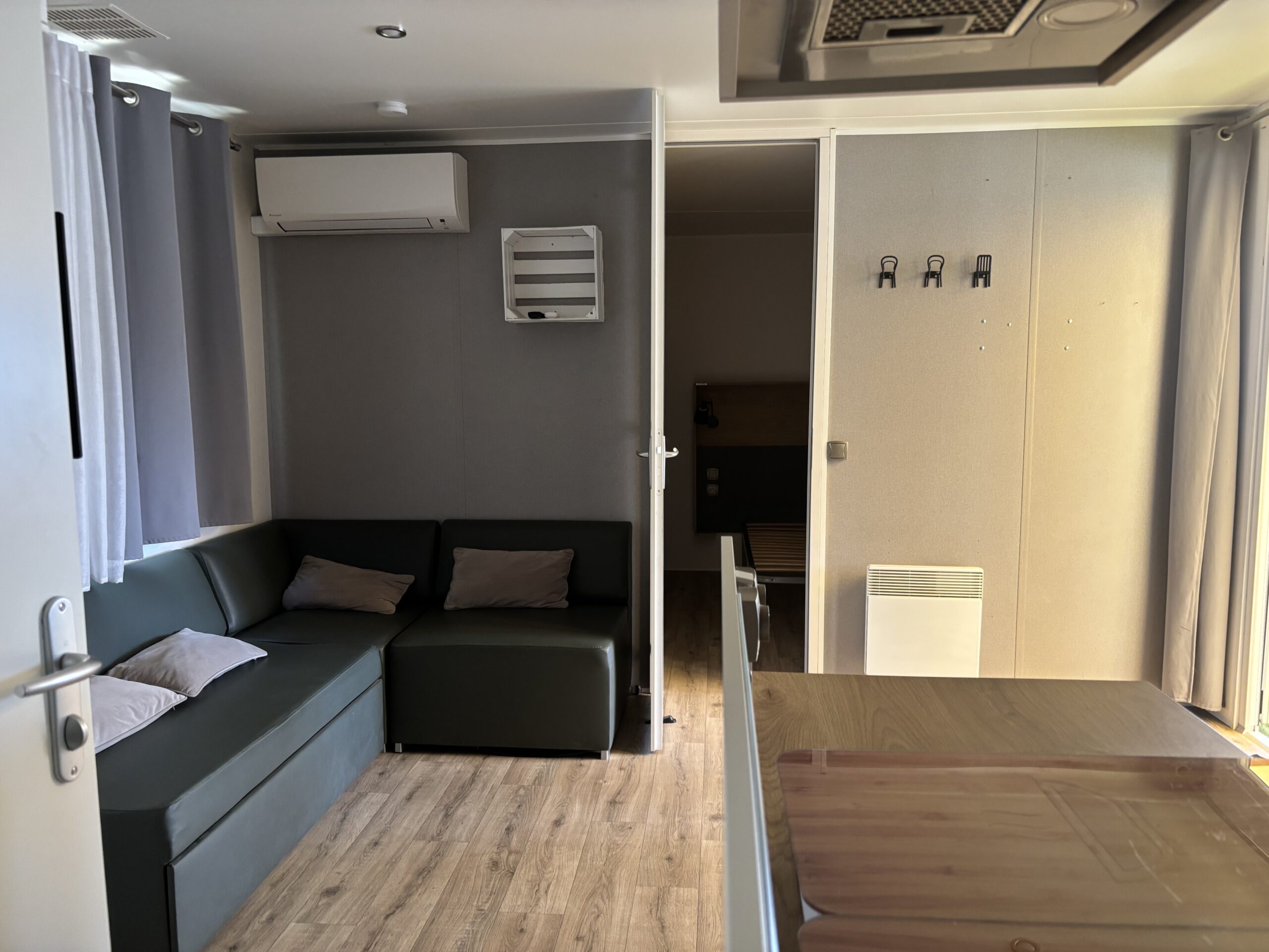 Salon d'un mobil-home du domaine, canapé d'angle noir