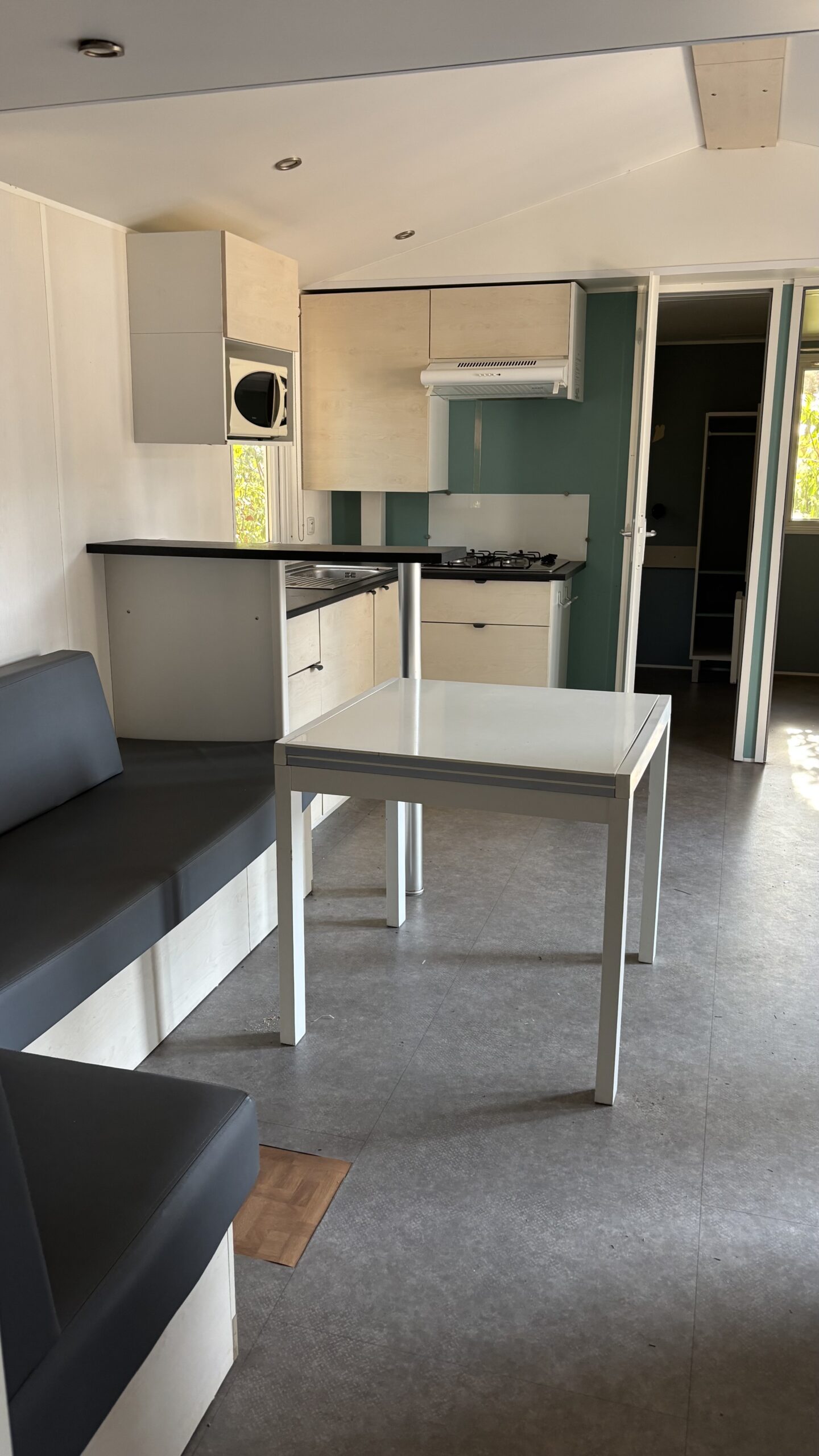 Vue d'ensemble d'un séjour de mobil-home, cuisine et salon lumineux