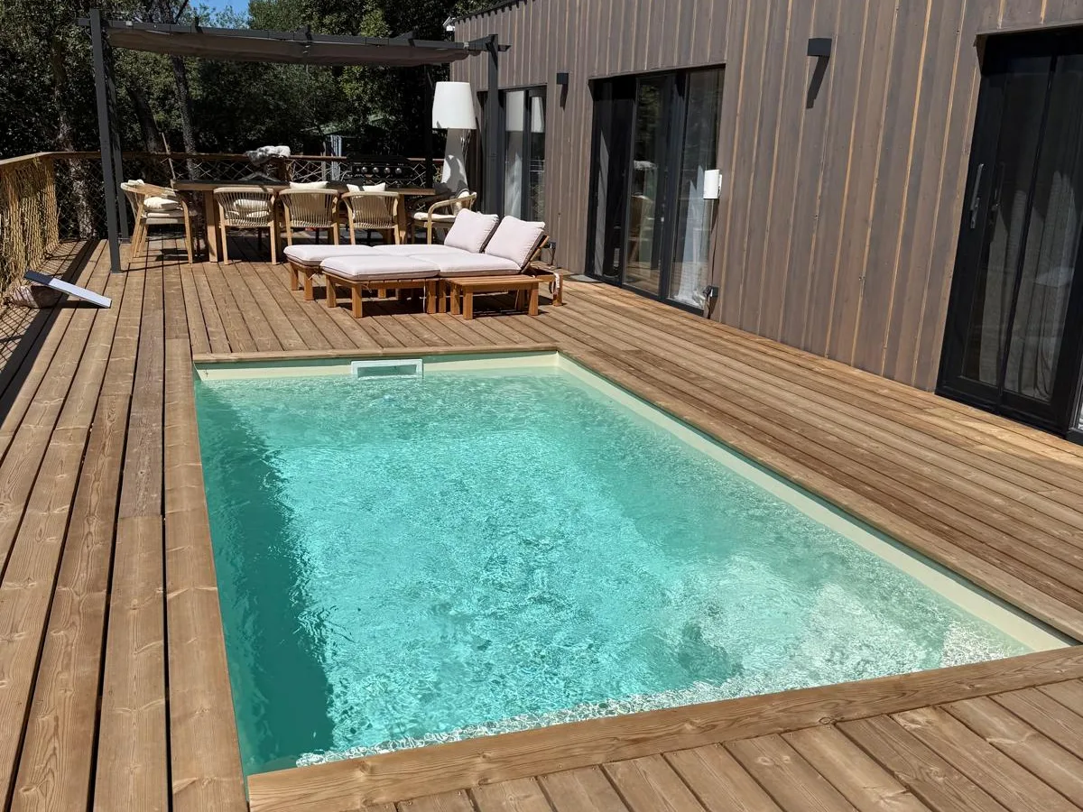 Terrasse en bois et piscine d'un chalet du domaine